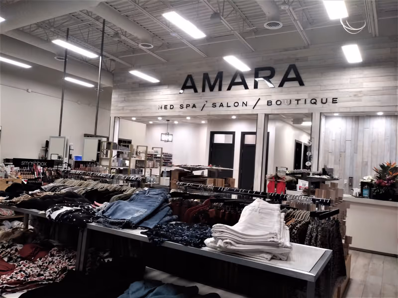 The completed Amara Med Spa, Salon & Boutique — a shiplap-clad signage wall above the boutique floor, with the salon stations and treatment rooms opening up behind it